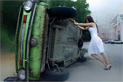 Woman in white dress pushing a car that rolled over